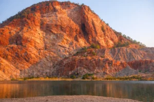 Red rock cliffs near Zion National Park with lake reflection, popular scenery featured on private Zion National Park tours