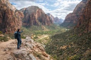 Hiker overlooking Zion National Park canyon landscape while exploring budget-friendly canyoneering routes