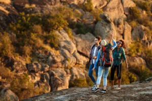 Group of hikers exploring rocky trails during a guided tour near Zion National Park at sunset.