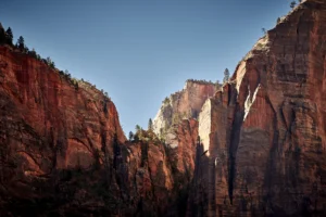 Towering red sandstone cliffs in Zion National Park under a clear blue sky in Southern Utah