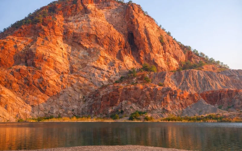 Red rock cliffs near Zion National Park with lake reflection, popular scenery featured on private Zion National Park tours